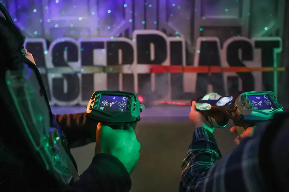 Players navigating a dark, fog-filled neon laser tag arena